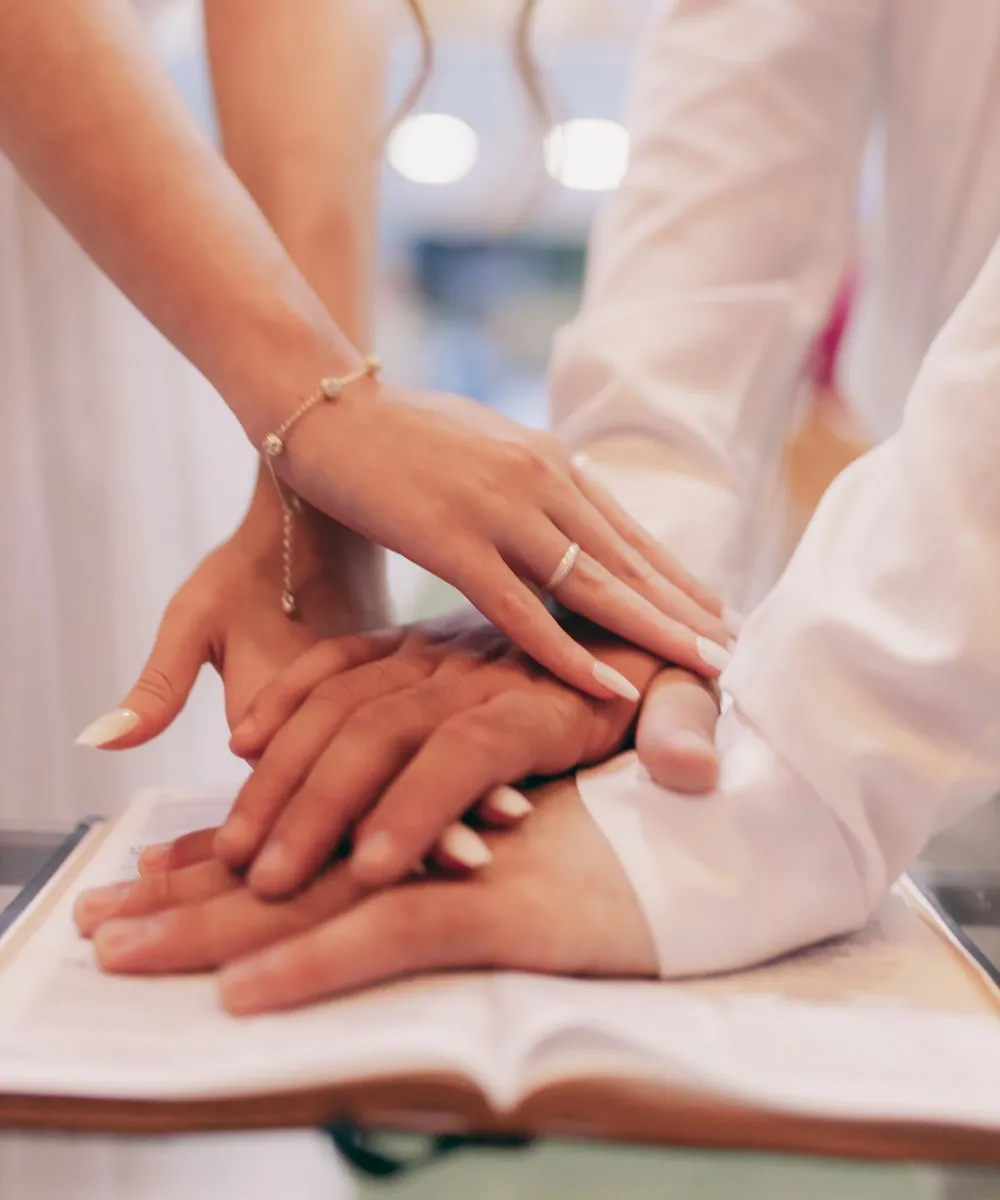 A doctor's hand resting over a patient's hands
