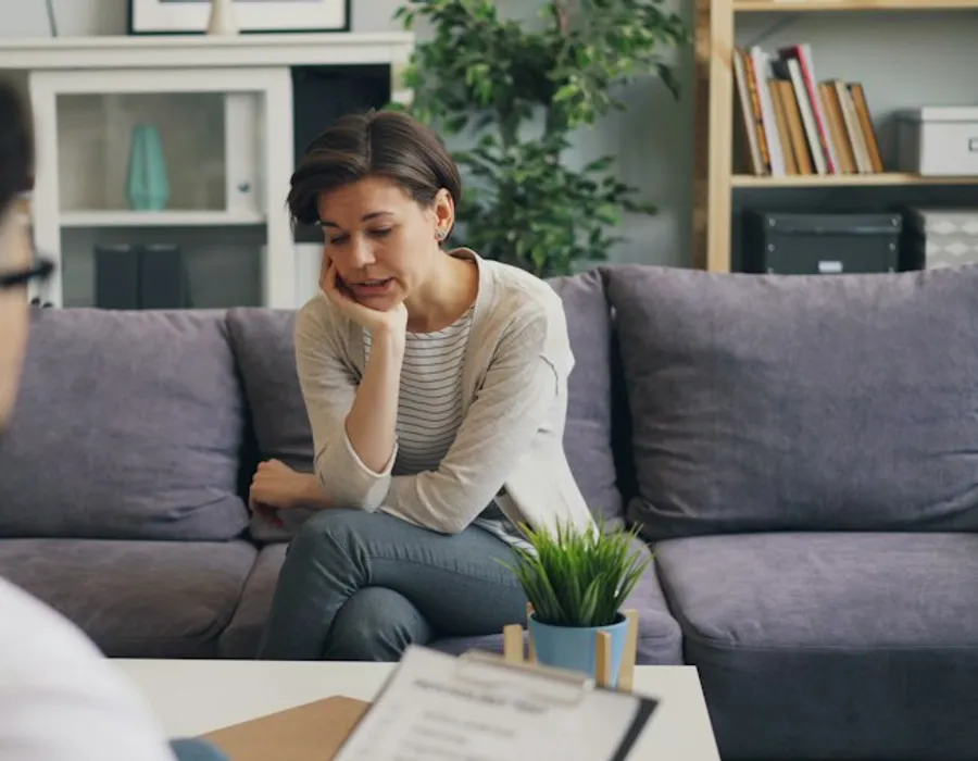 A woman sitting on a sofa in a counselling room